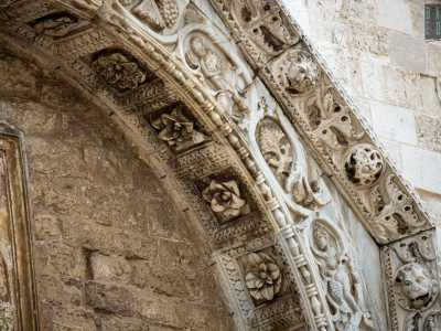 La cornice del timpano � adorna di teste leonine e di pomi traforati intervallati da fogliame di acanto, mentre l'archivolto (decorato nell�intradosso da lacunari con rosette)...